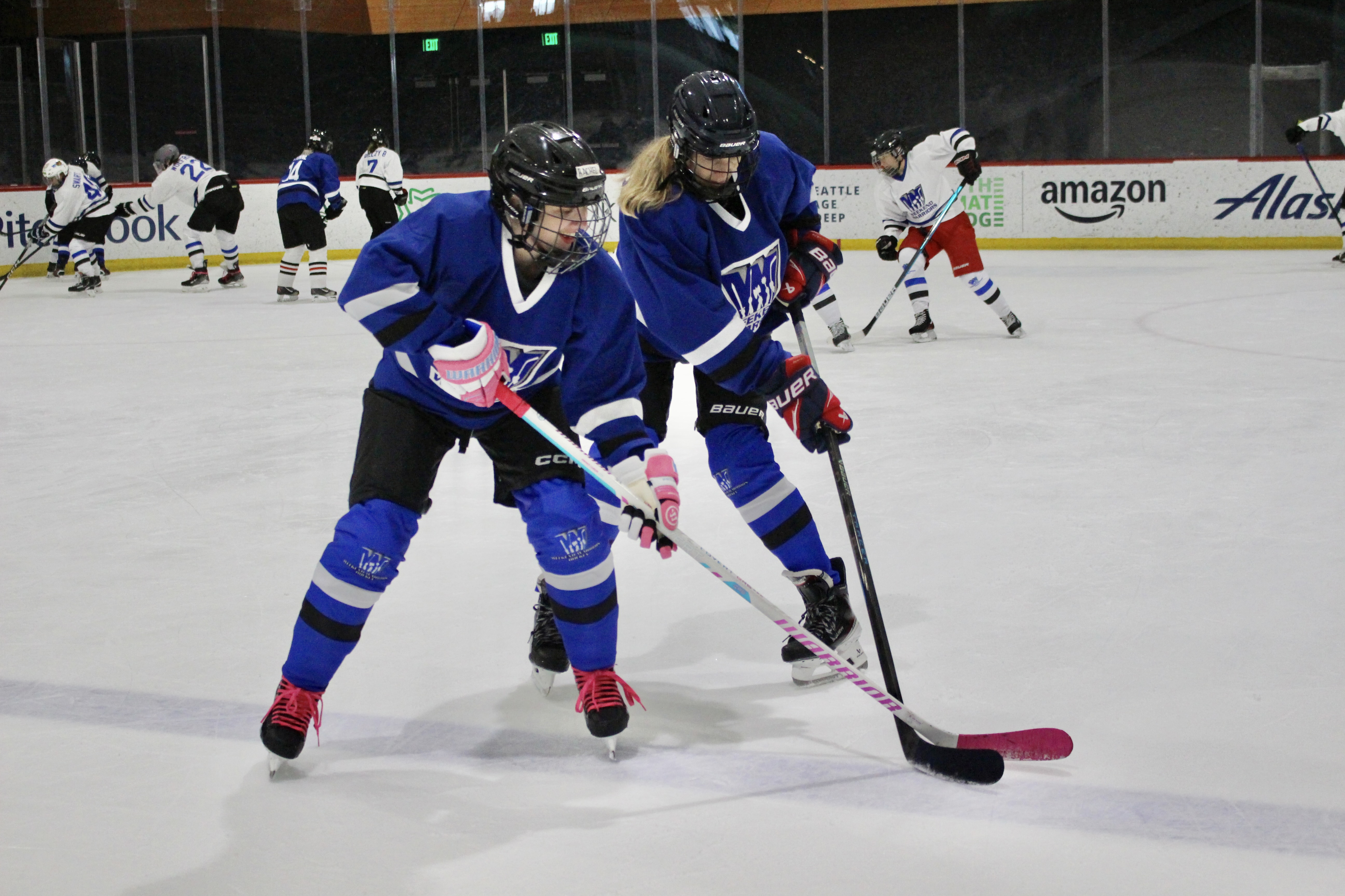 Two players battle for the puck and Weekend Warriors hockey camp.